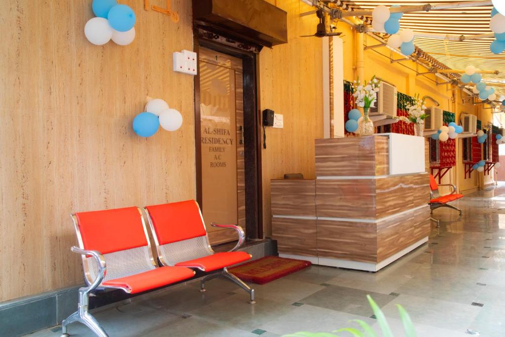 a waiting room with a red chair in a building at AL Shifa Residency in Mumbai