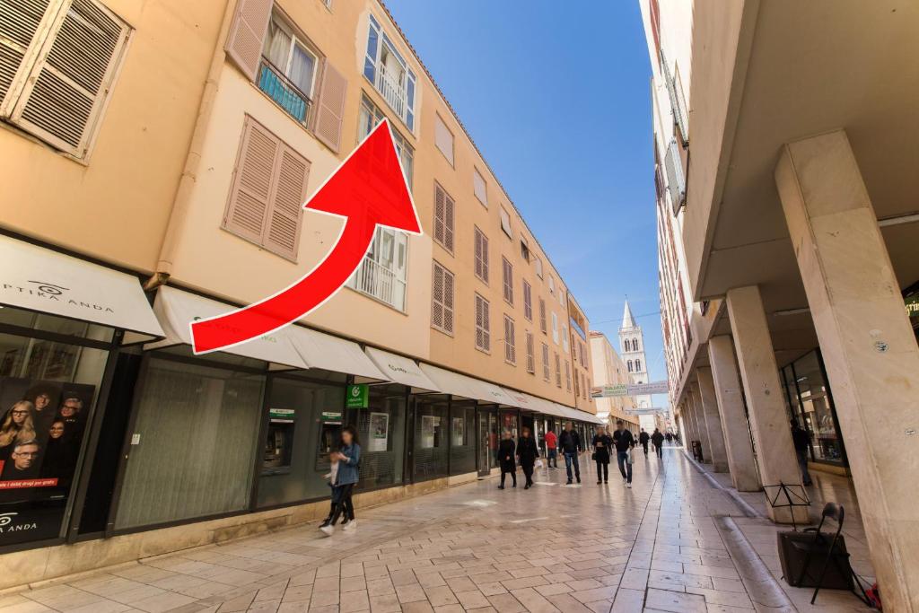 una señal de flecha roja colgando del costado de un edificio en Apartment Main Street Zadar en Zadar