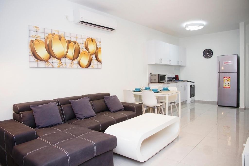 a living room with a couch and a kitchen at Apartments4you Maya in Bat Yam