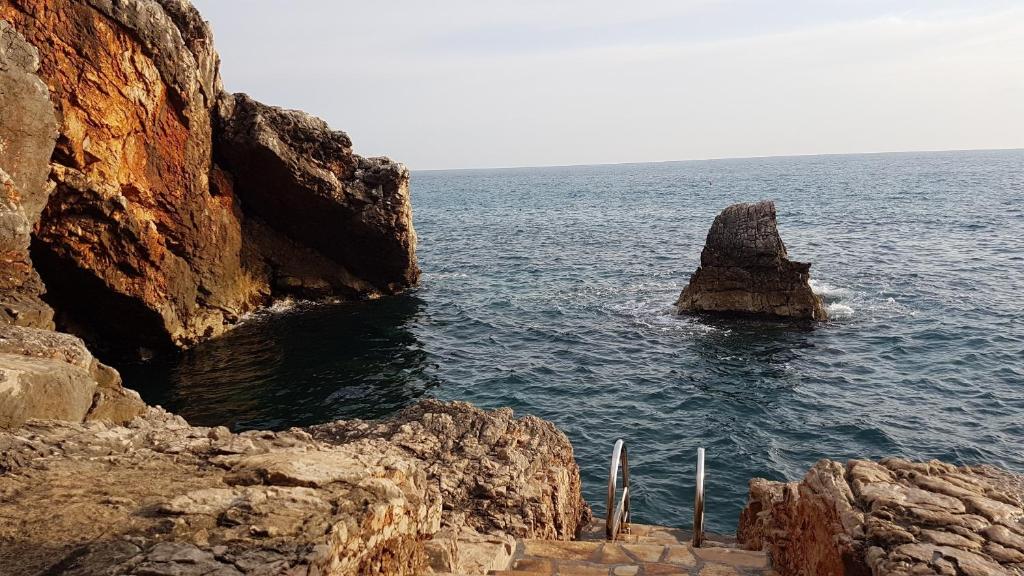 a rock formation in the water next to the ocean at Apartman Haris in Dobra Voda