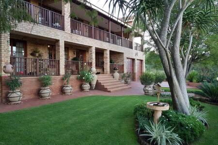 a building with a green lawn in front of it at The Garden Room in Buffelspoort