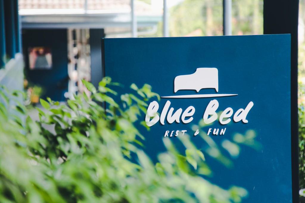 a blue sign that reads blue eyed with a hat at Blue Bed Hotel in Chanthaburi