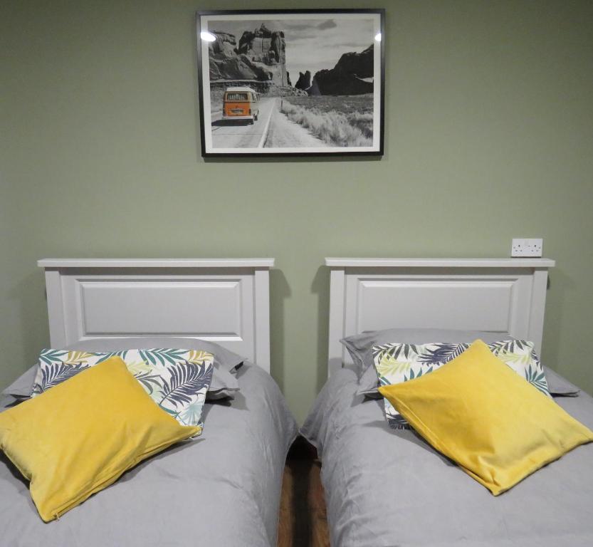 two beds sitting next to each other in a room at Wildwood Apartment in Carlingford