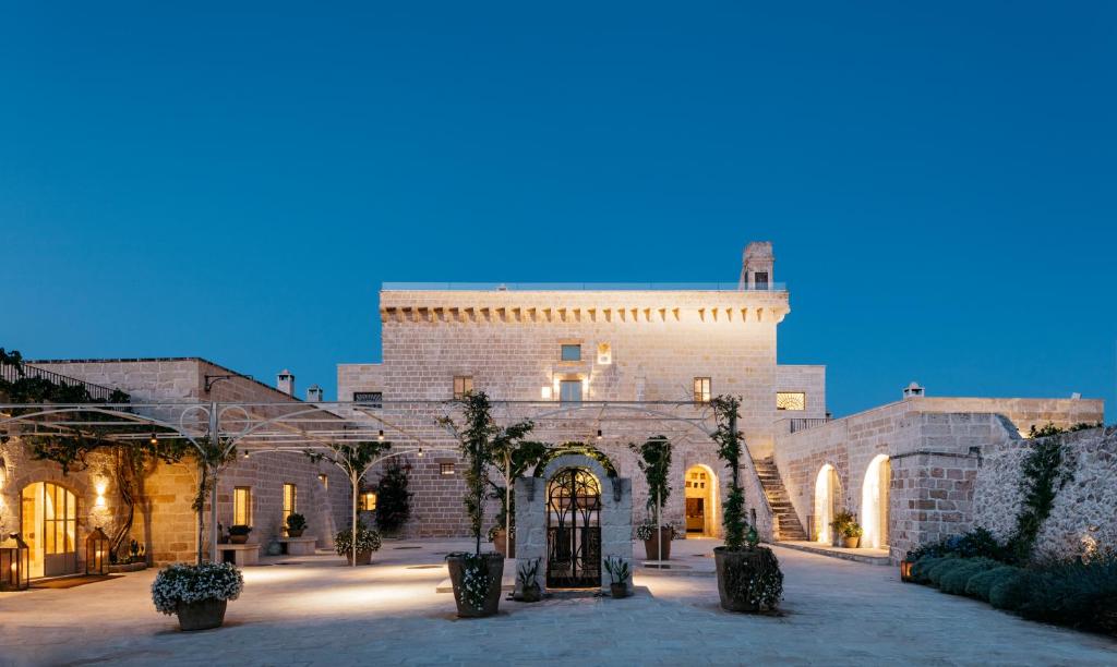 a large brick building with trees in a courtyard at Masseria Trapana in Lecce