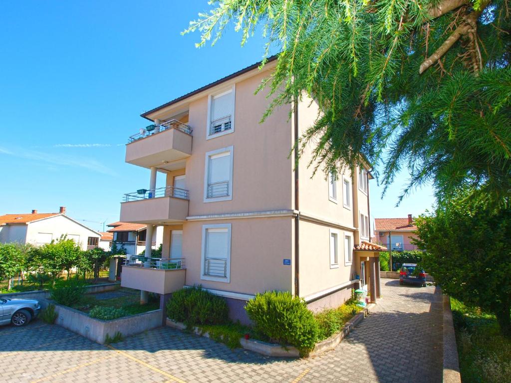 ein großes Apartmenthaus mit einer Palme in der Unterkunft Apartments Majda 1932 in Fažana