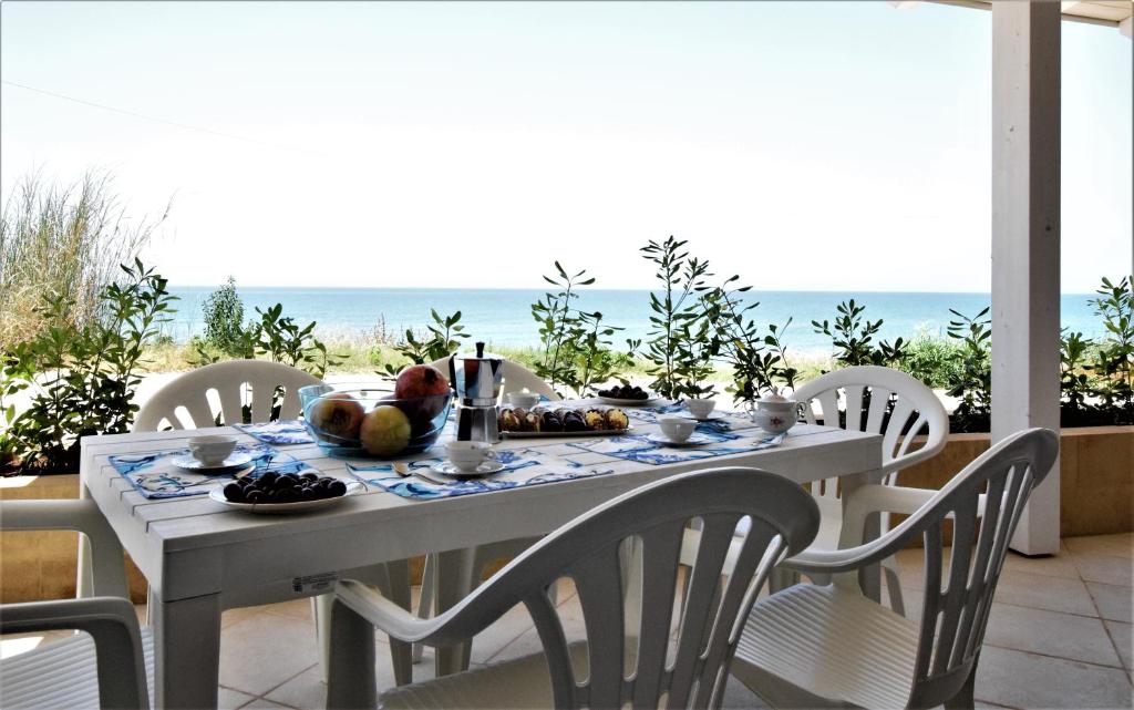 stół z jedzeniem i ocean w tle w obiekcie Covo dei Marinai w mieście Cava dʼAliga