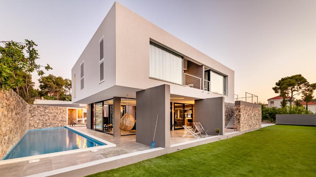 a modern house with a swimming pool and a yard at Villa Petra in Sutivan