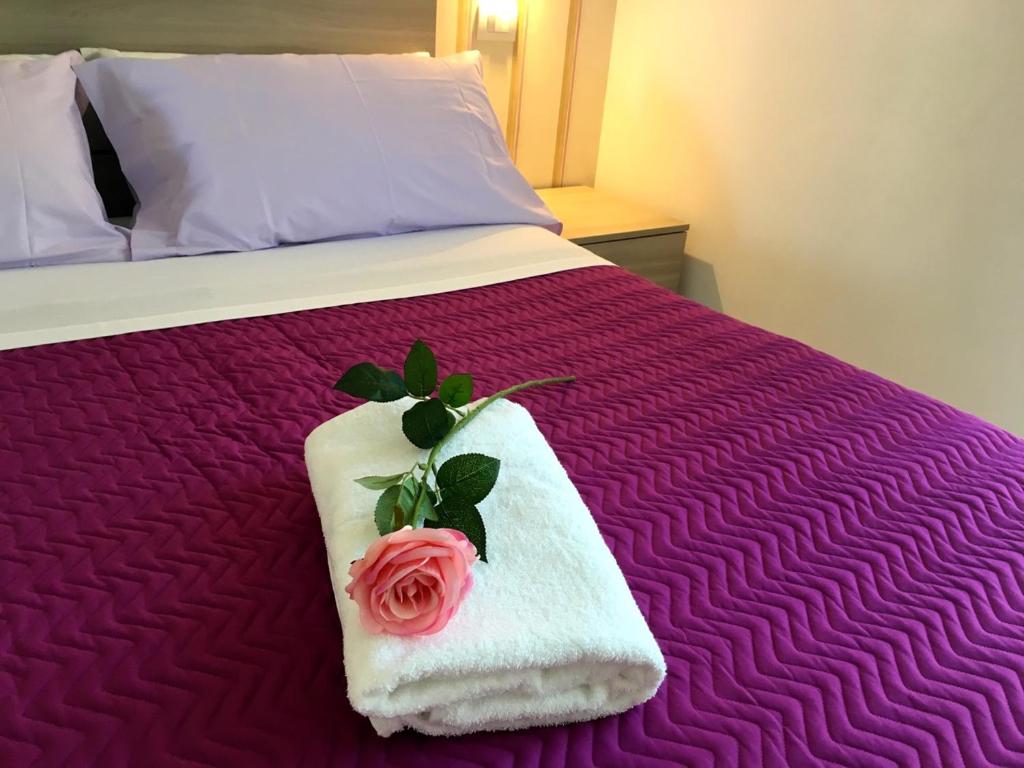 a bed with a towel with a rose on it at Soffio del mare in Lido di Fermo