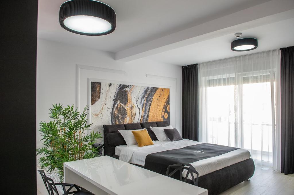 um quarto com uma cama, uma mesa e uma janela em WEST RESIDENCE APARTMENTS em Timişoara