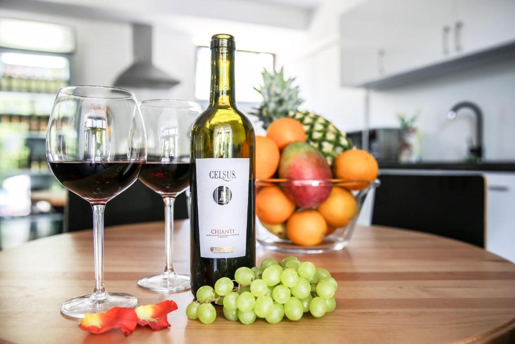 two glasses of wine and fruit on a table at Hotel Vincent in Luhačovice