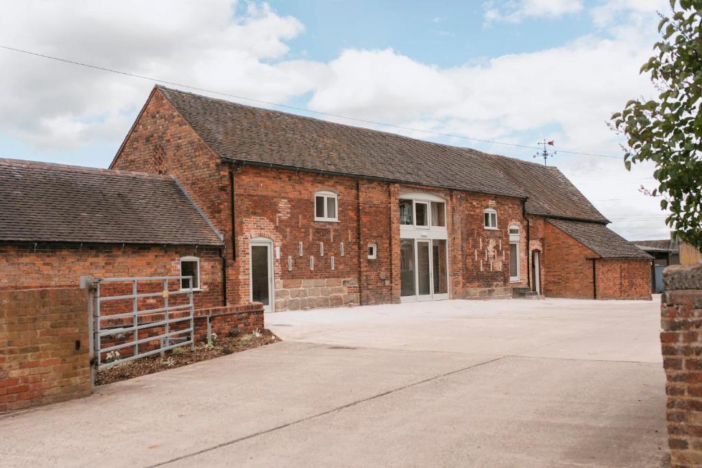 an old red brick building with a garage at Tuppenhurst Barn in Rugeley