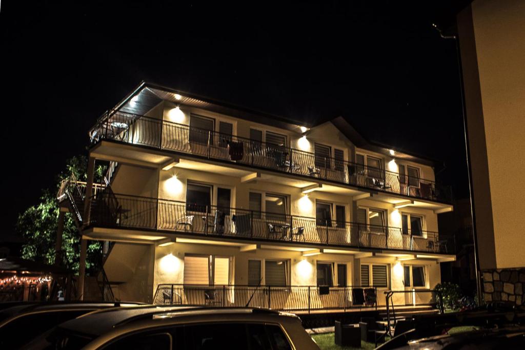 a white building with balconies and lights on it at Pokoje Gościnne Wiola in Władysławowo