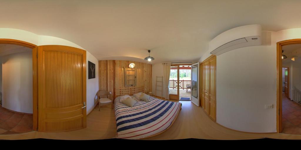 Un dormitorio con una cama con una manta a rayas. en Chambres d'Hôtes La Téouleyre, en Saint-Julien-en-Born