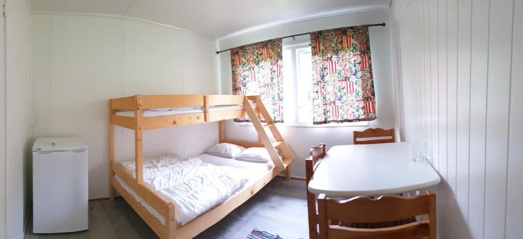 a small room with a bunk bed and a table at Romsdalseggen Camping in Isfjorden