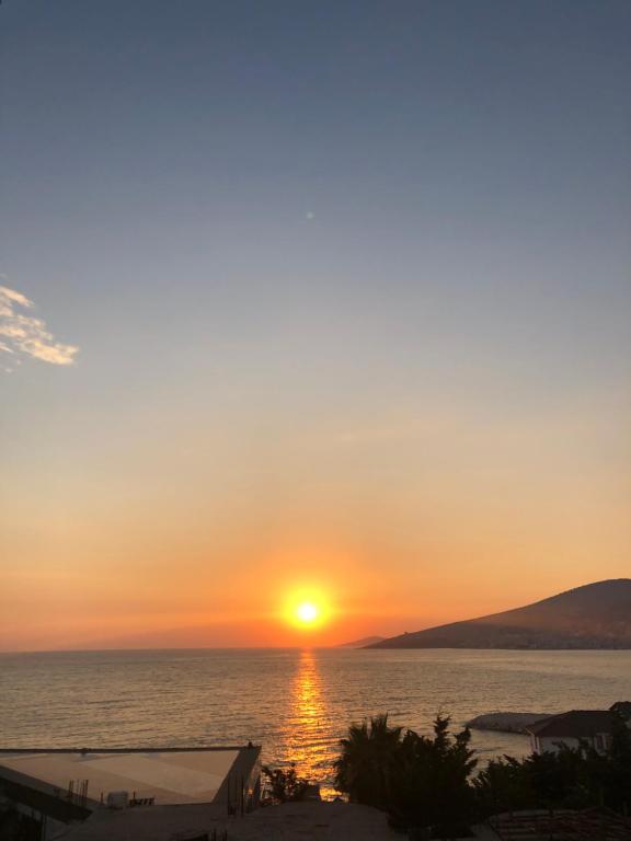 a sunset over the ocean with the sun setting at Hotel Sole in Sarandë