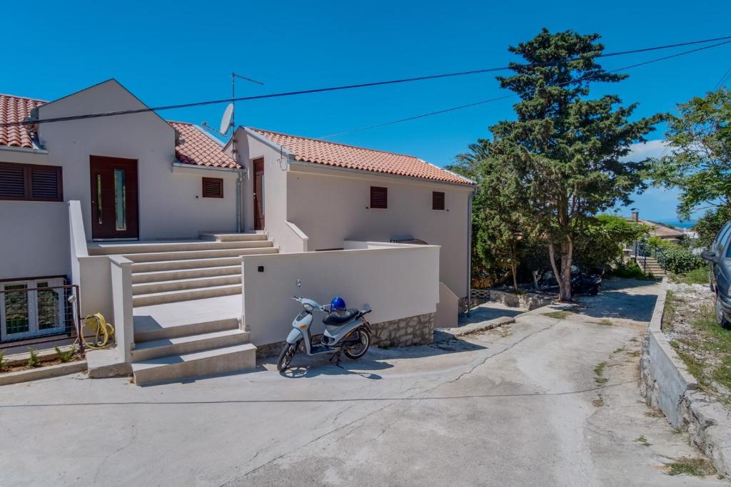 ein Motorrad, das vor einem Haus geparkt ist in der Unterkunft Wonderful House Sandra in Mali Lošinj