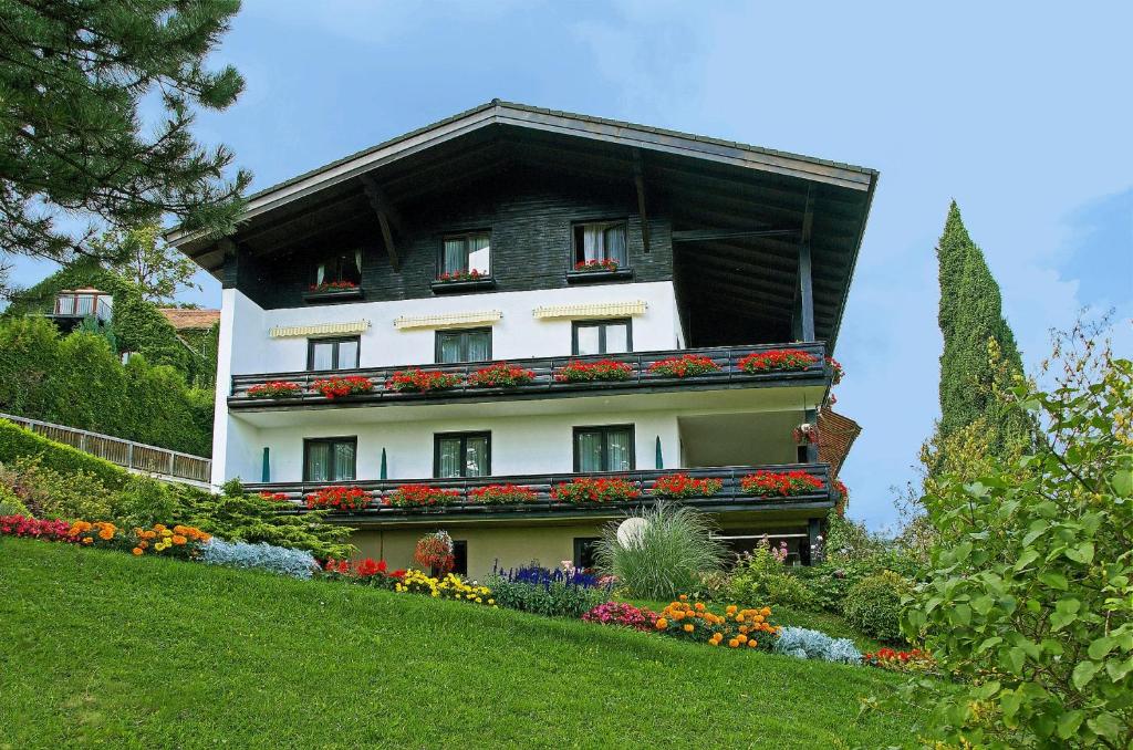 ein Haus mit Blumen an der Seite eines Hügels in der Unterkunft Pension Seirer in Sankt Radegund bei Graz