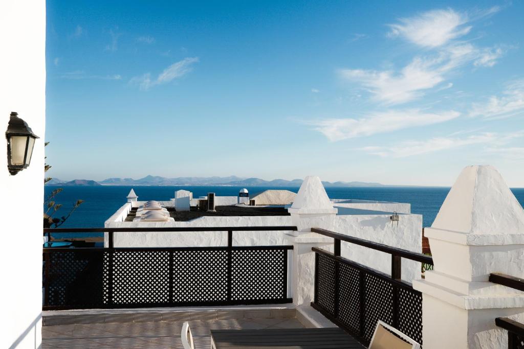 a view of the ocean from the balcony of a house at Hotel LIVVO Volcán Lanzarote in Playa Blanca