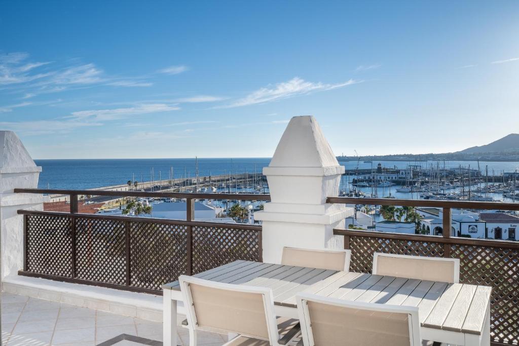 a balcony with a table and chairs and the ocean at Hotel LIVVO Volcán Lanzarote in Playa Blanca