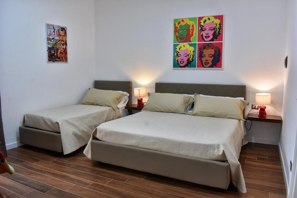 - une chambre avec 2 lits, 2 lampes et un tableau dans l'établissement b&b Donna Raffaela, à Crotone