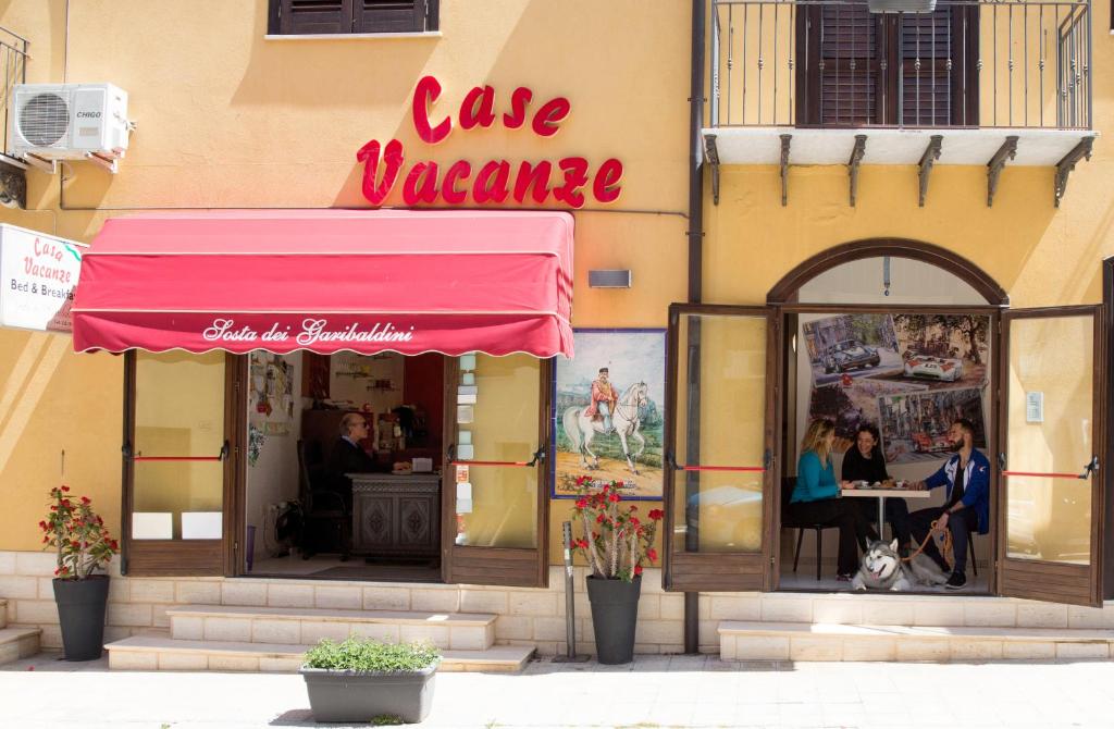 a restaurant with a pink awning on a building at Sosta dei Garibaldini in Campofelice di Roccella