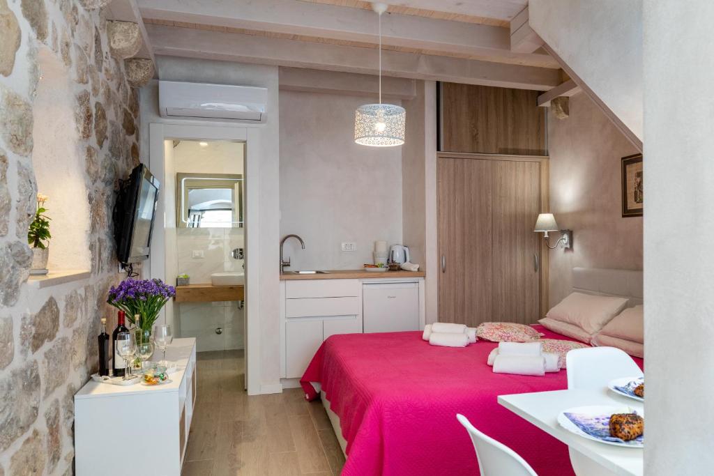 a room with a red bed with a kitchen in it at Old town Marko in Dubrovnik
