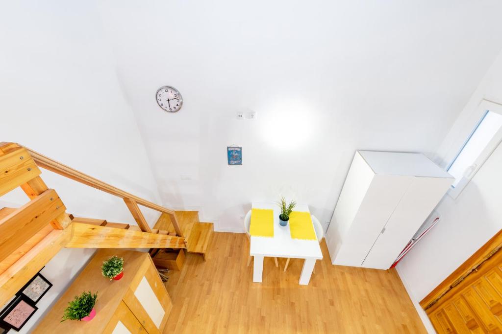 an attic room with a table and yellow chairs at Duplex Lavapies 1BD in Madrid