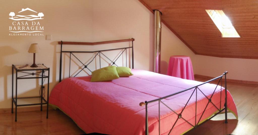 sypialnia z łóżkiem z czerwoną kołdrą w obiekcie Casa da Barragem w mieście Montalegre