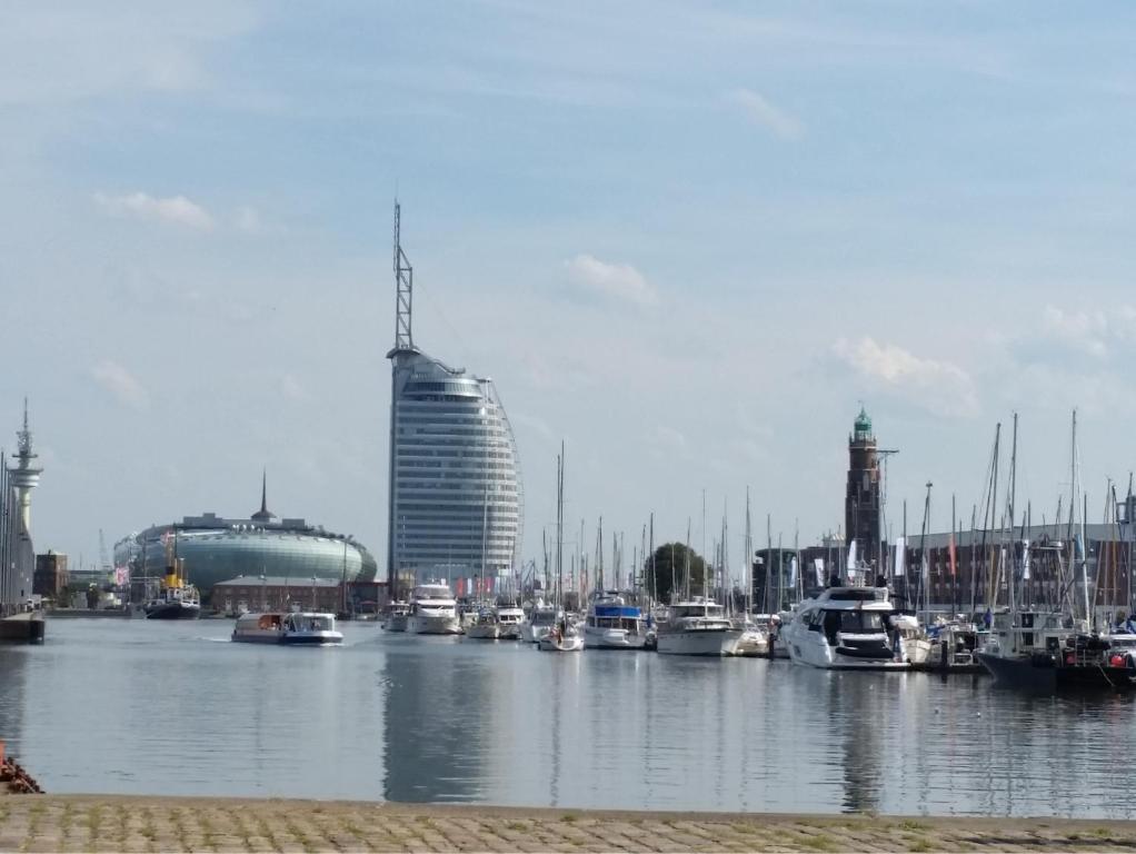 a group of boats docked in a harbor with buildings at Ferienwohnung Koralle - Am Wasser in Bremerhaven