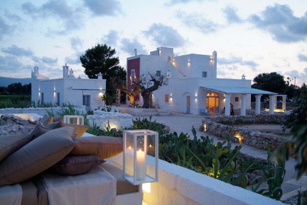 una grande casa bianca con luci in cortile di Masseria Cimino a Savelletri