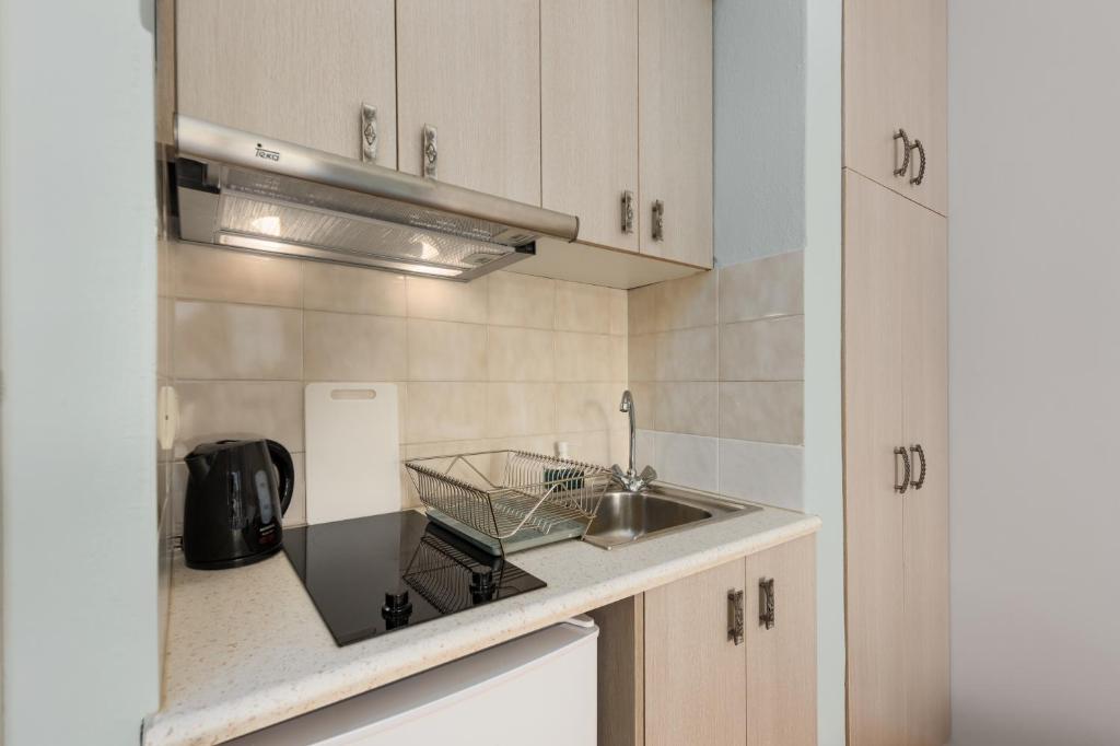 a kitchen with a sink and a counter top at Pansion Ermioni in Skala