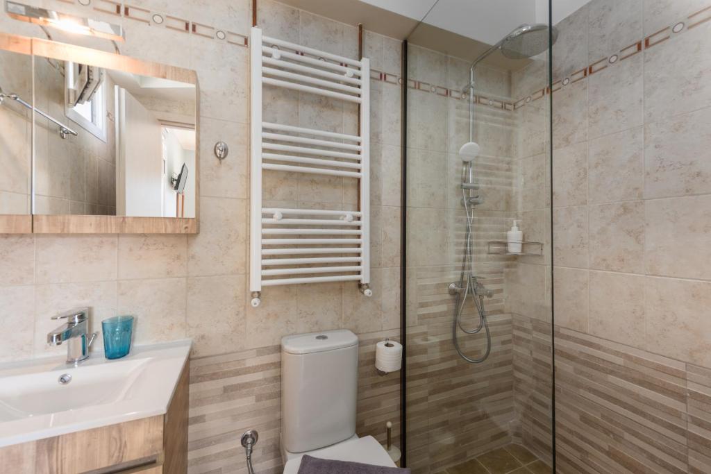 a bathroom with a shower and a toilet and a sink at Pansion Ermioni in Skala