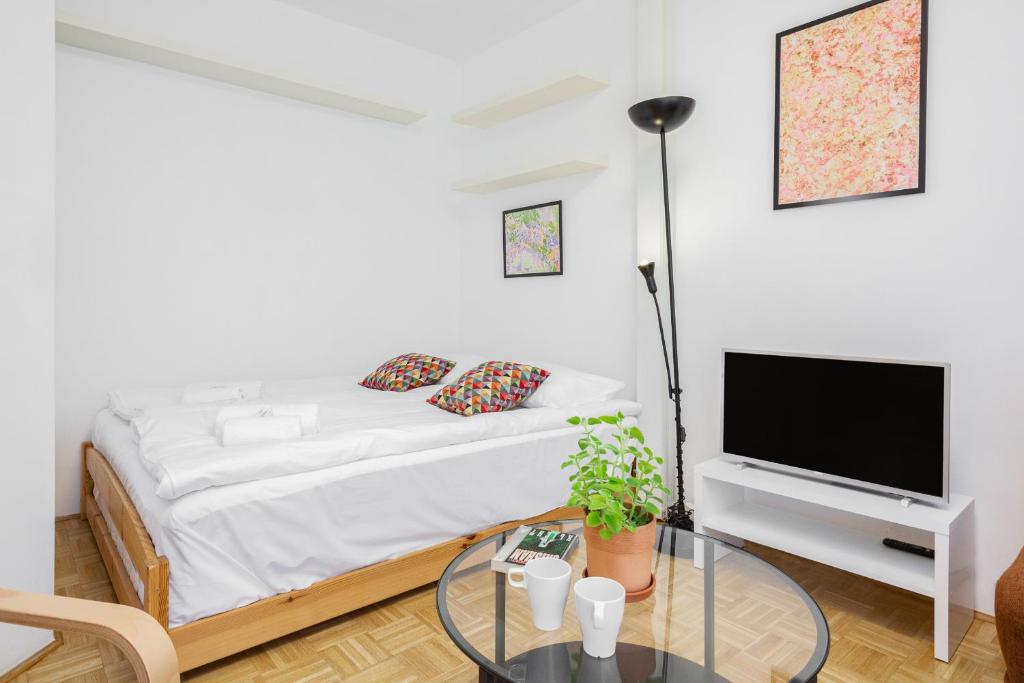 1 dormitorio con 1 cama, TV y mesa en Apartments Warsaw Kakowskiego by Renters en Varsovia