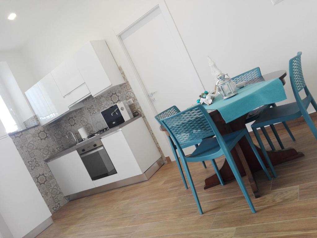 a small kitchen with a blue table and chairs at TalialETNA Apartments in Nicolosi