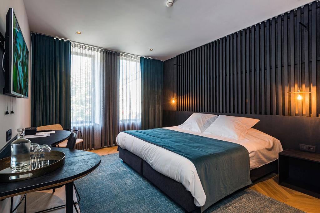 une chambre d'hôtel avec un lit et une table dans l'établissement Hotel Beila, à Bilzen