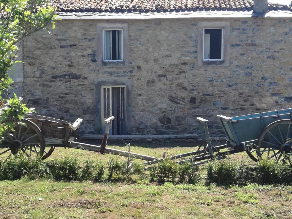 une ancienne voiturette devant un bâtiment en pierre dans l'établissement Casa rural Trabe, à Cedeira