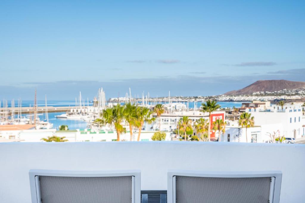 a view of a harbor from a balcony with two monitors at Hotel LIVVO Volcán Lanzarote in Playa Blanca
