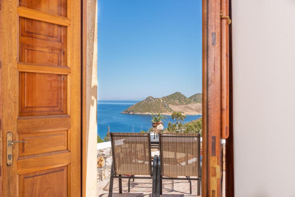 een open deur naar een balkon met uitzicht op de oceaan bij Apartment Nektarios in Grikos