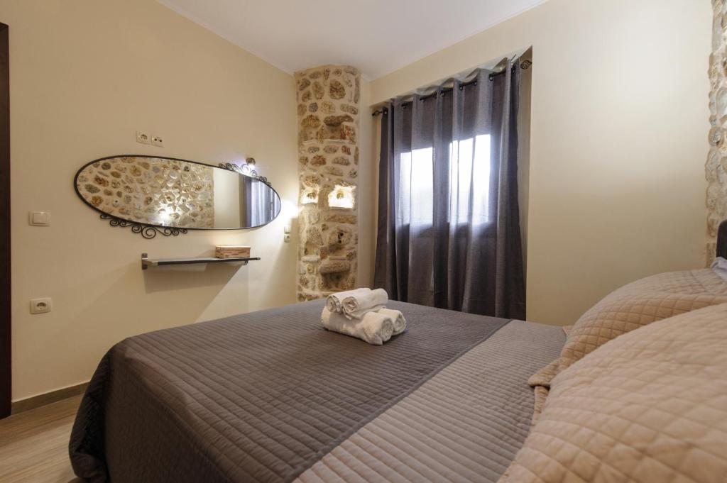 een slaapkamer met een bed en een spiegel aan de muur bij To Petrino (VIlla Markos) in Parga