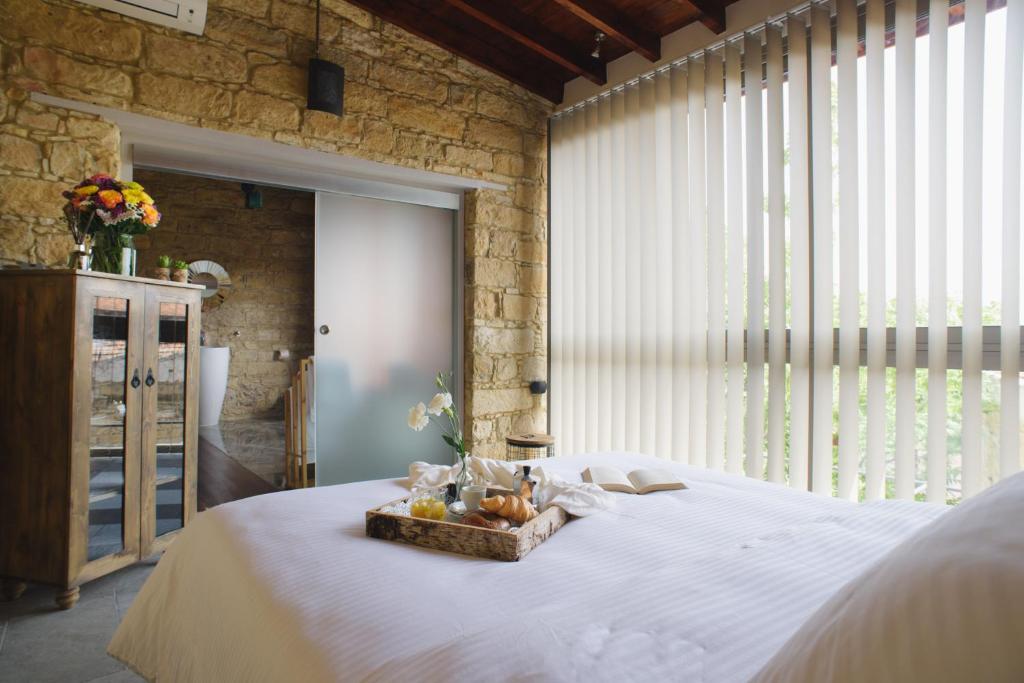 a bedroom with a white bed and a large window at Serenity Boutique House in Vouni