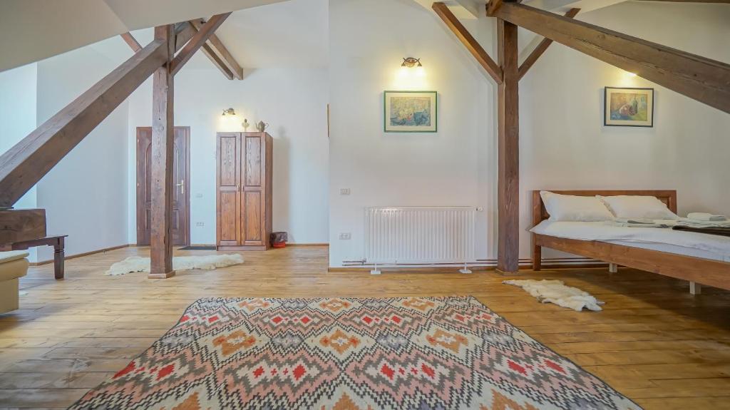 a bedroom with a bed and a rug on a wooden floor at Baiulescu apartments in Braşov