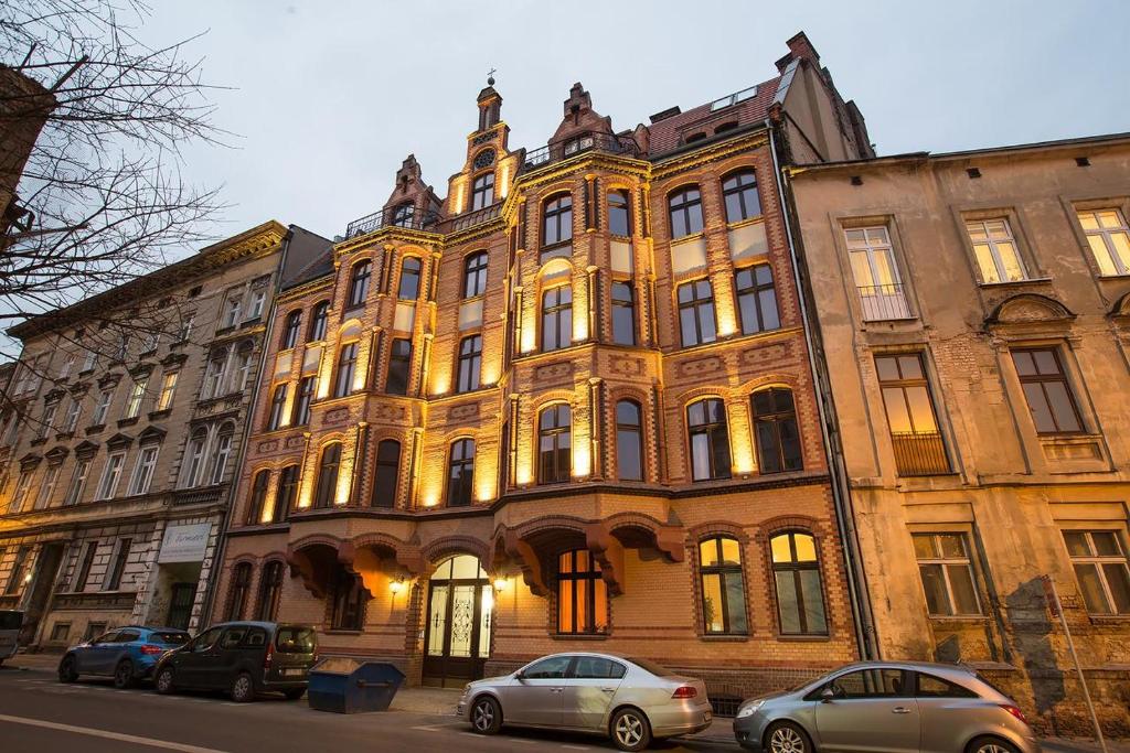 ein großes Gebäude mit davor geparkt in der Unterkunft Loft Apartments Poznań in Posen