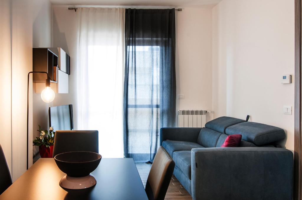 a living room with a blue couch and a table at Fonte Laurentina Apartments in Rome