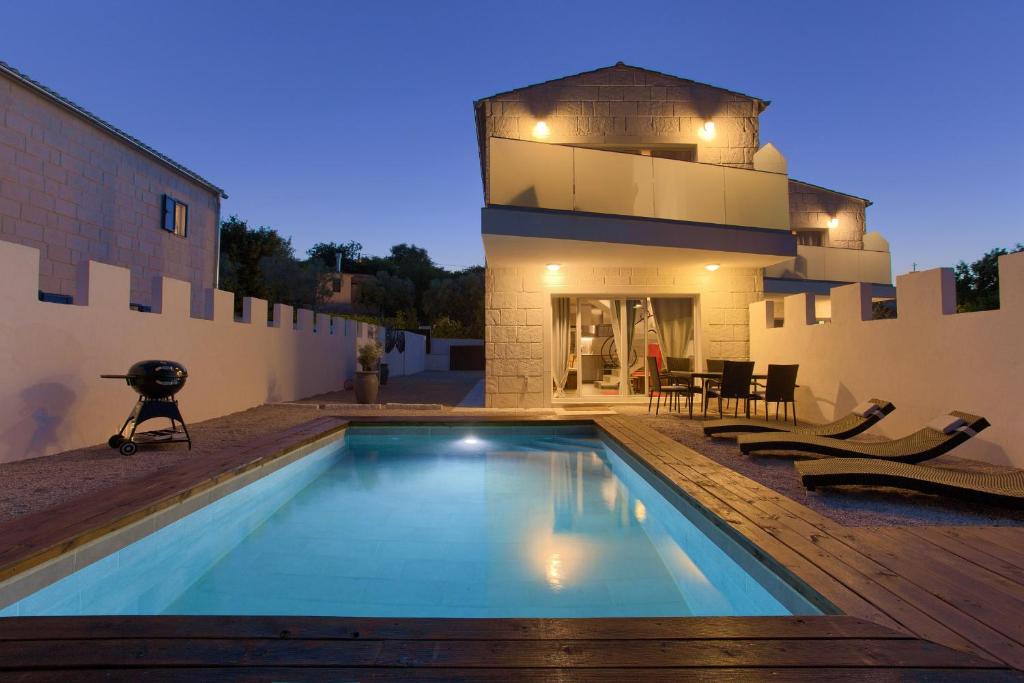 a swimming pool in front of a house at Pax Houses in Krk