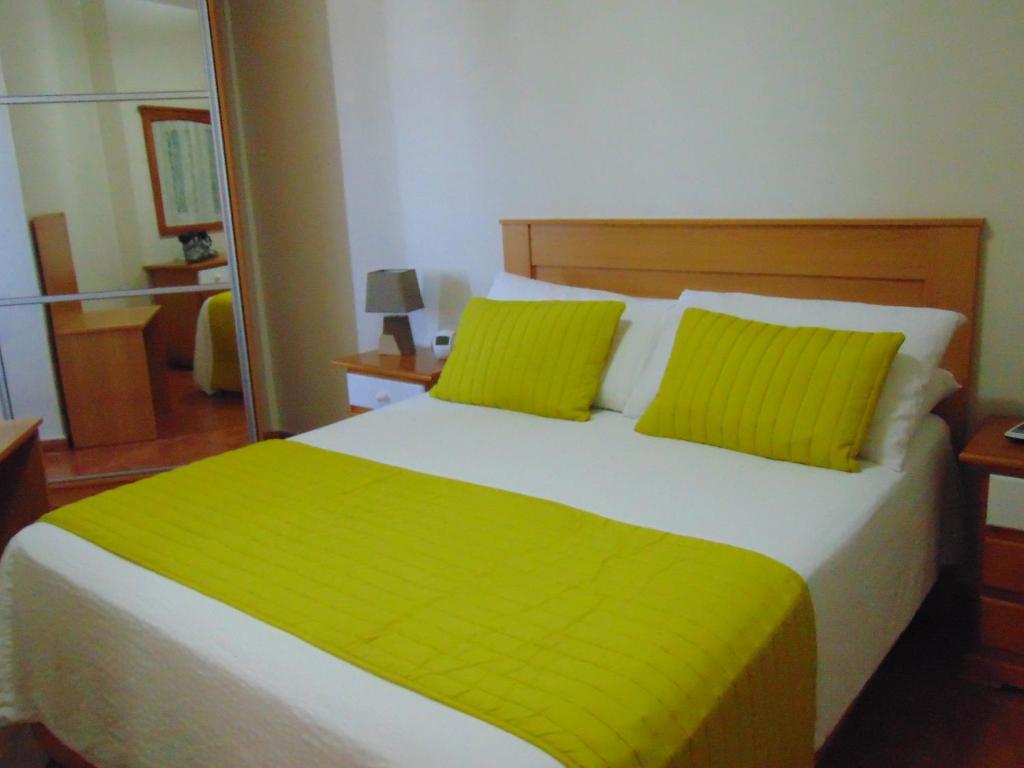 a bedroom with a large bed with lime green pillows at Aeropuerto in Carrizal