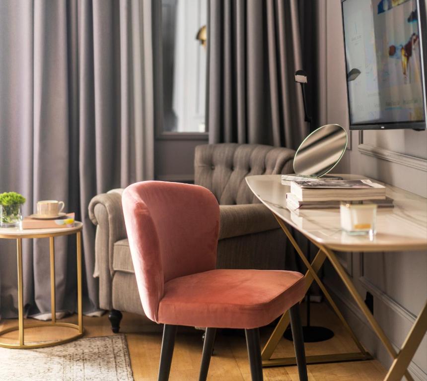 a living room with a chair and a desk at Hotel Excelsior in Dubrovnik