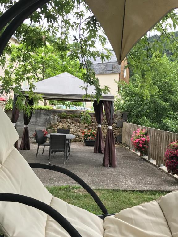 a backyard with a tent and a table and chairs at Chambres d'Hotes du Moulin de Lachaux in Châteauneuf-les-Bains