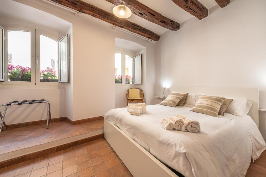 una camera da letto con un grande letto bianco con due asciugamani sopra di Remy apartment a Cagliari
