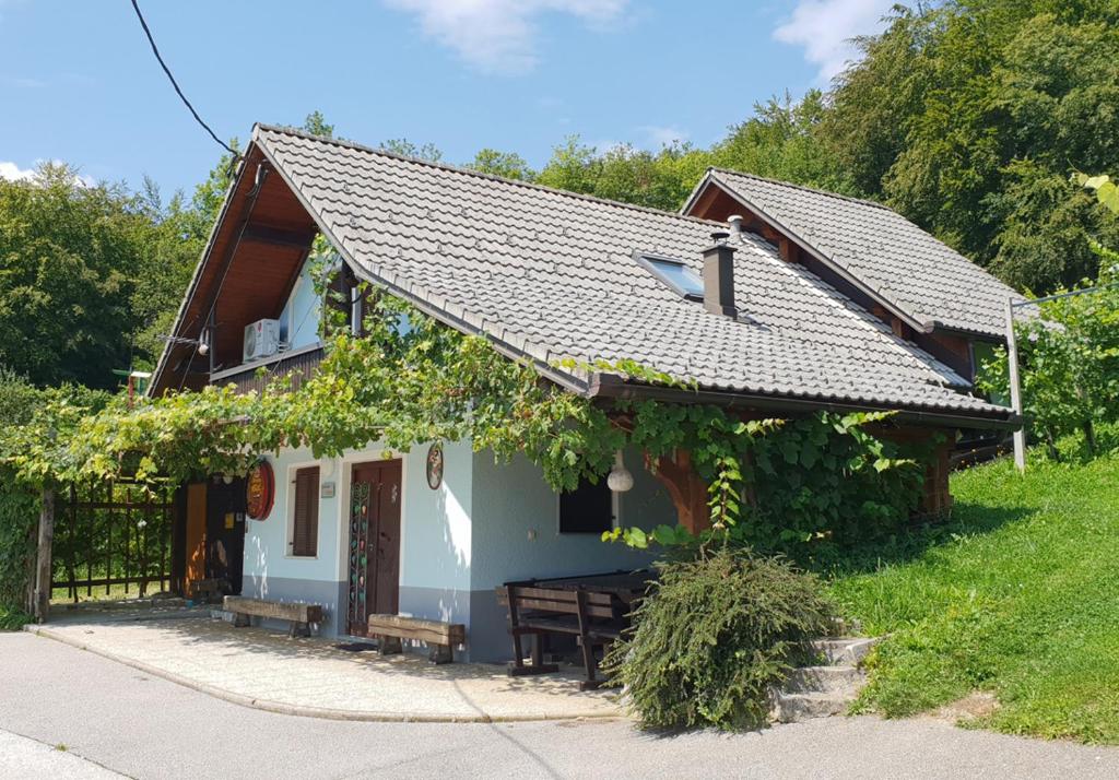 une petite maison avec une terrasse couverte et une clôture dans l'établissement Zidanica Meglič - Vineyard cottage Meglič, à Trebnje