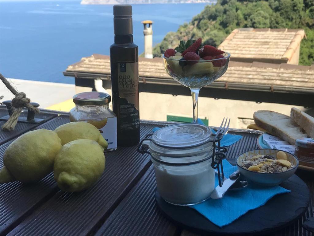 a table with a bowl of fruit and a glass of wine at il Magàn - Cinque Terre in Corniglia
